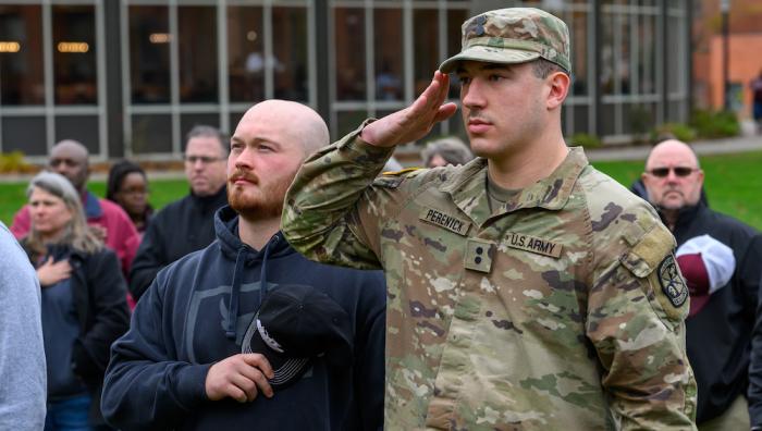 A veteran-student salutes during Veterans Day ceremony