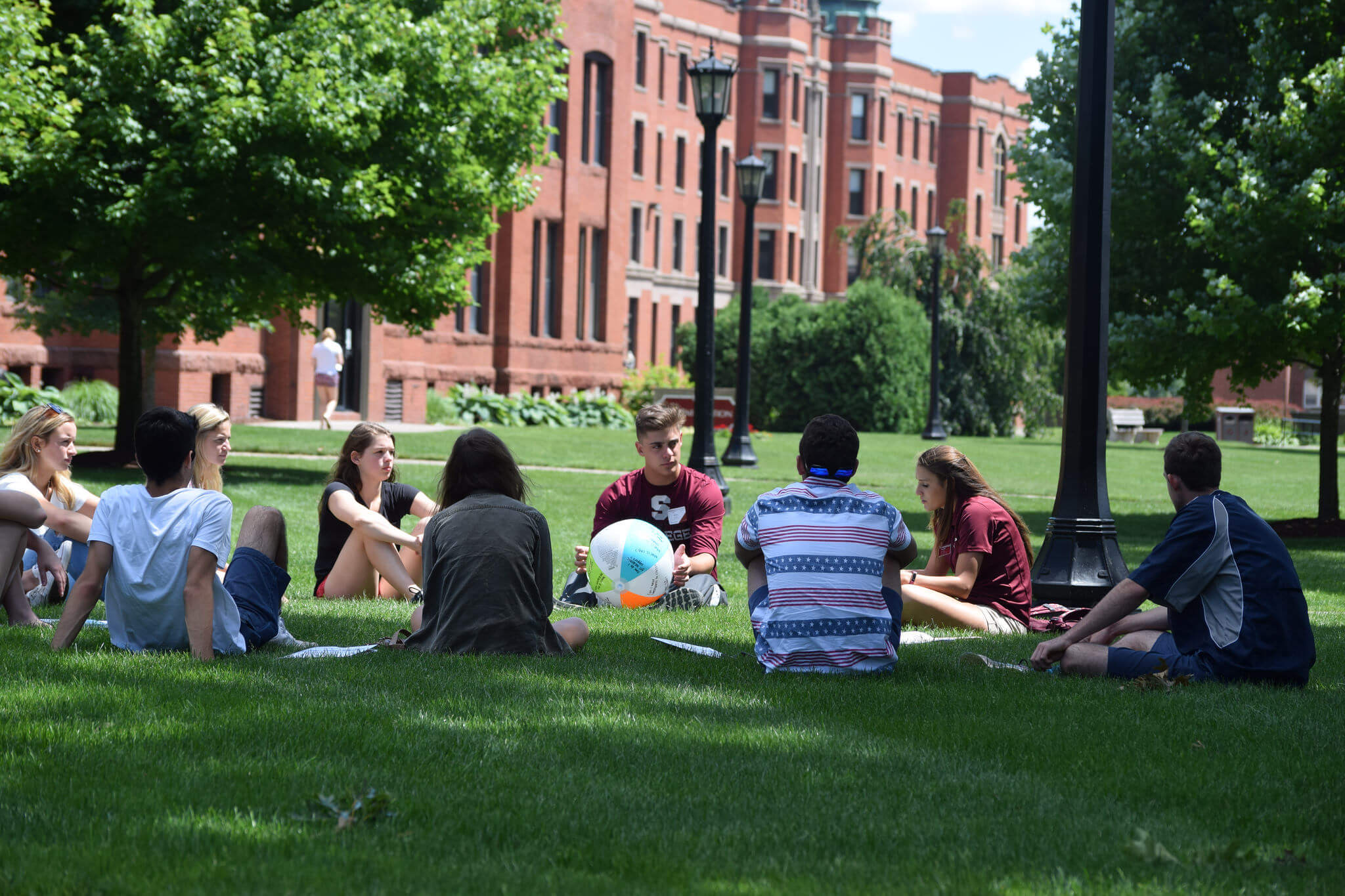Students sitting in a circle on Naismith Green. 