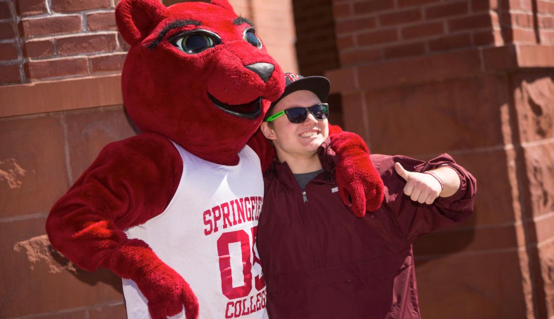 A student poses with the mascot