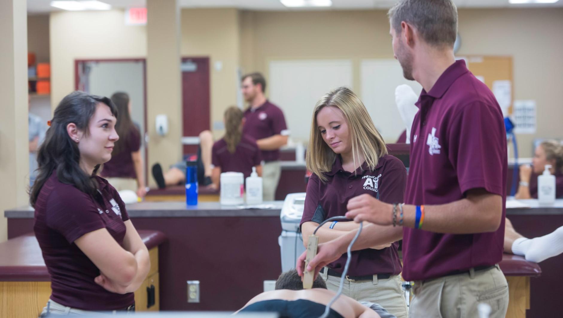 An athletic training student performs treatment on a client's back int he athletic training facility