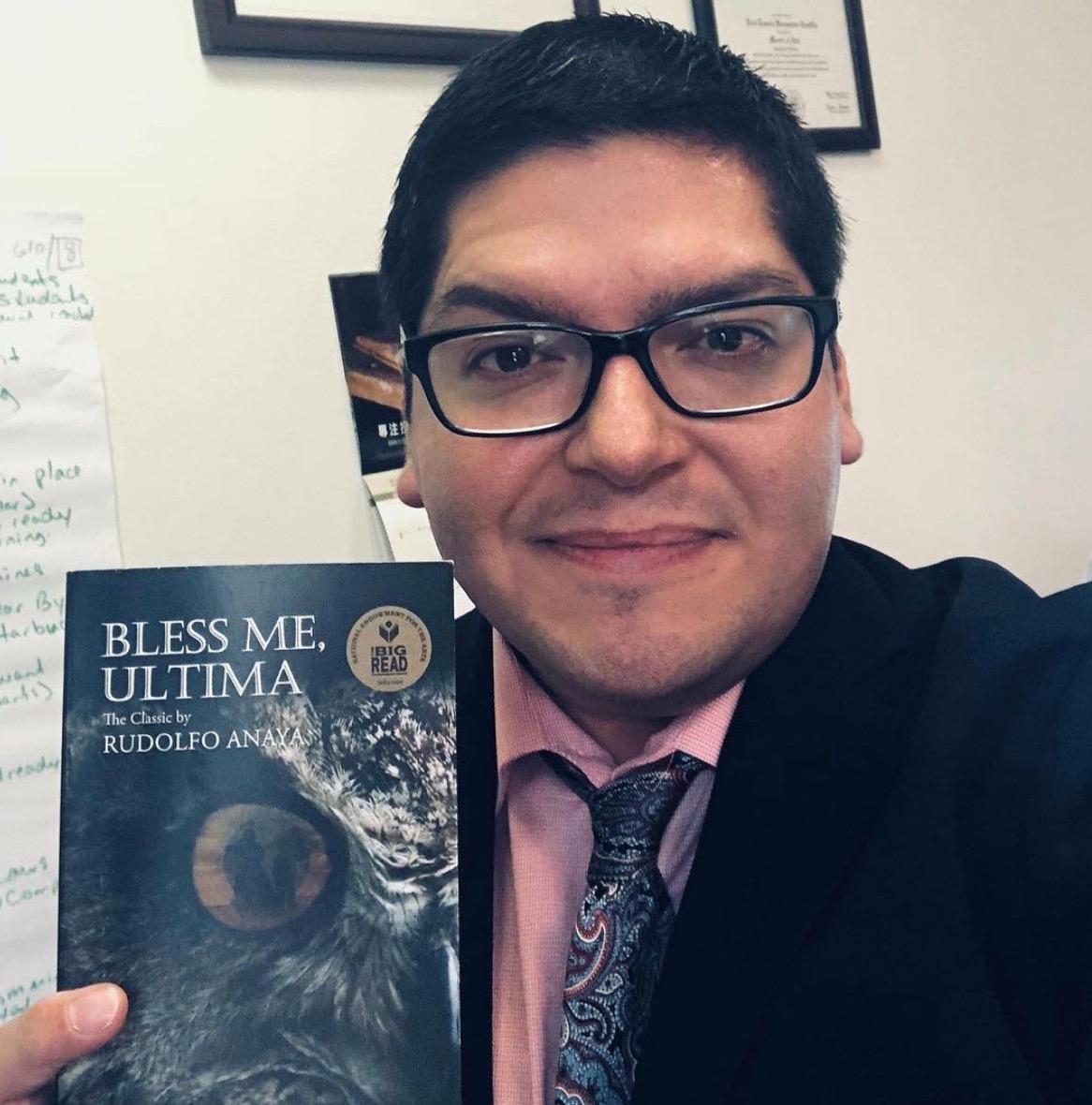 Eric Castillo hold a copy of Bless Me, Ultima