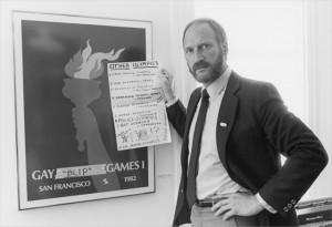 Tom Waddell stand next to the Gay Games poster in 1980s